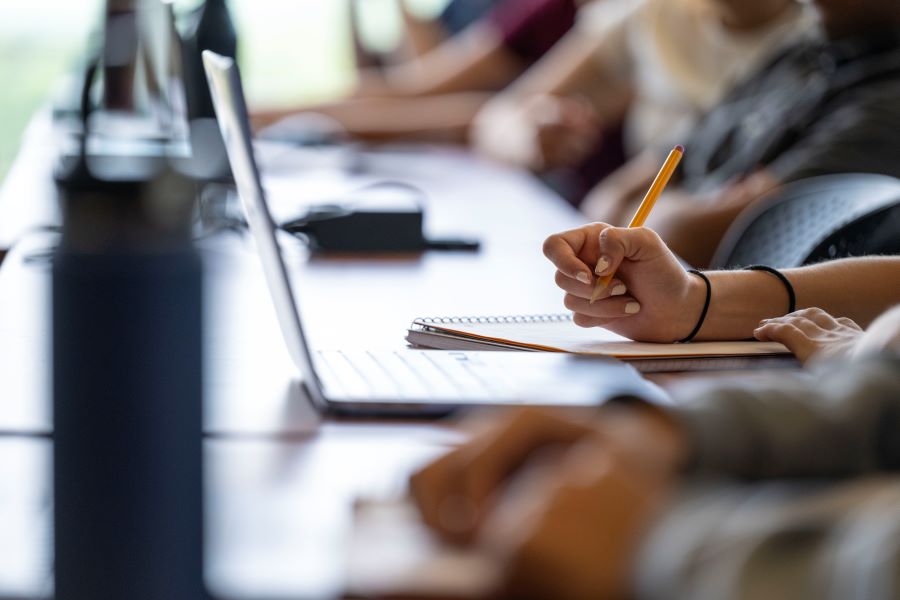 stock image with open laptop and hand holding pencil